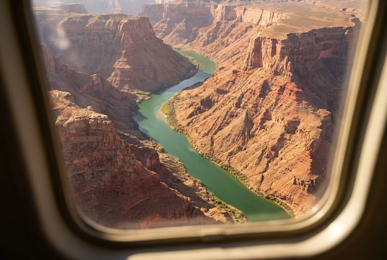 Aerial view of the Colorado River snaking between Grand Canyon West rim walls from a helicopter