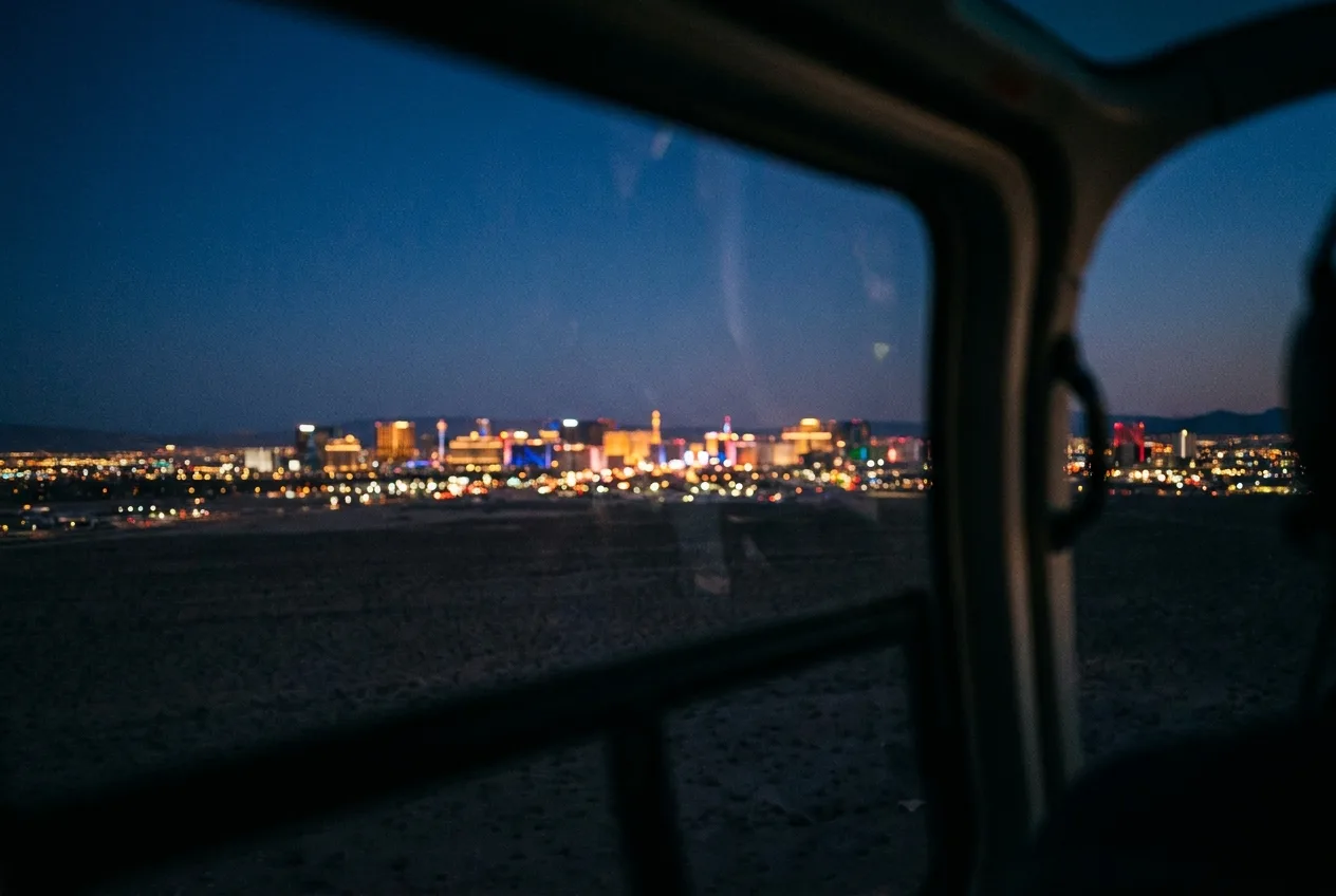 The Las Vegas night skyline from a helicopter approaching over dark desert